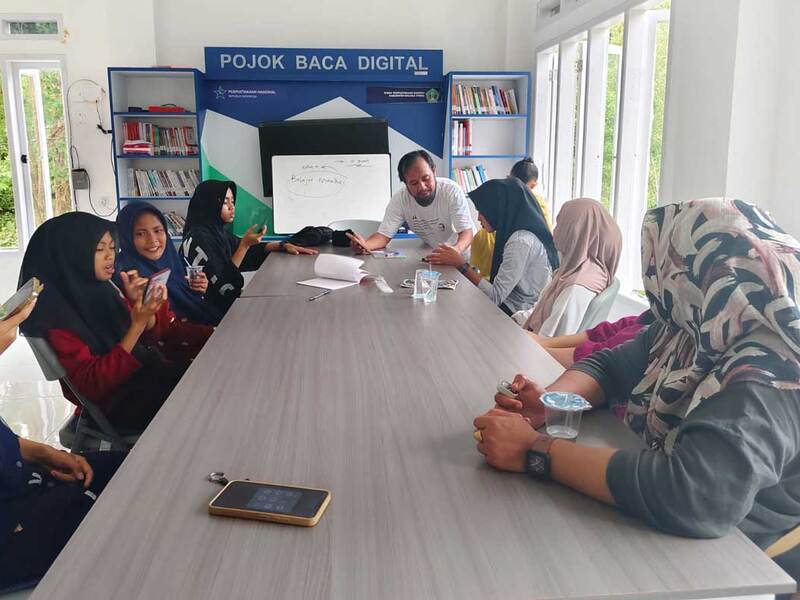 Villagers gathered for a peer-led English-learning session in Woitombo, Indonesia